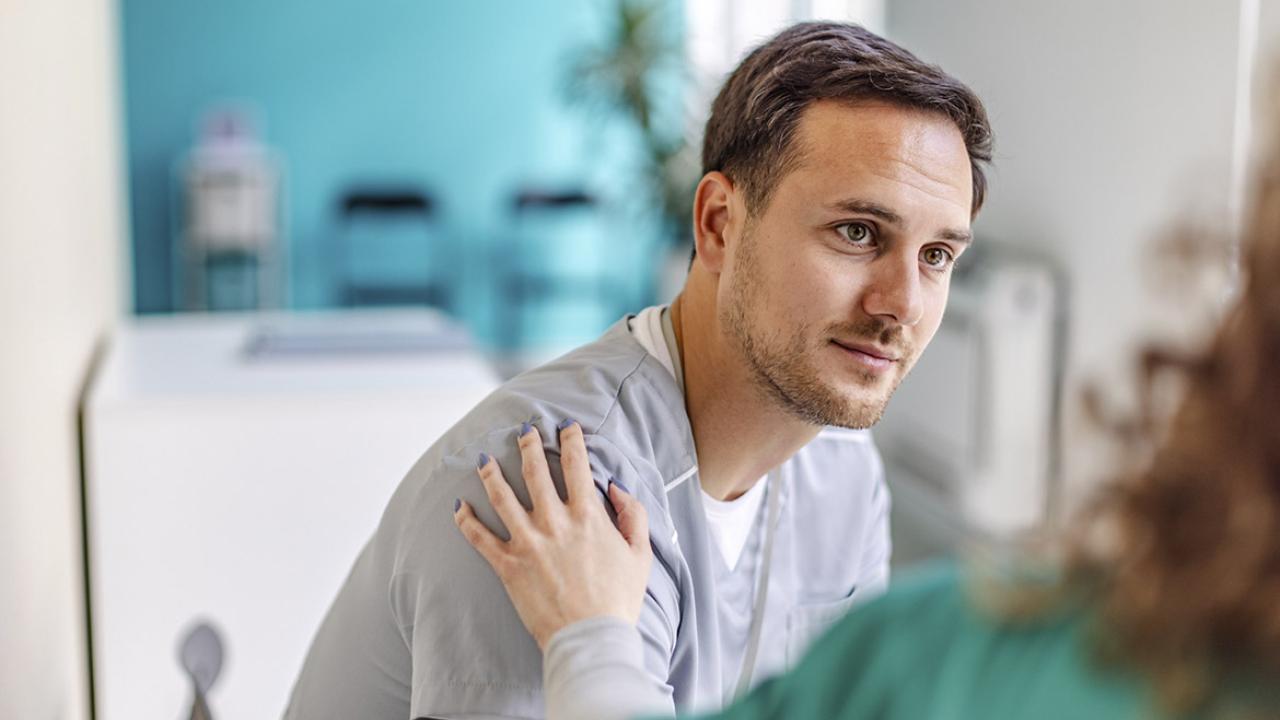 Healthcare worker with hand on patient's shoulder