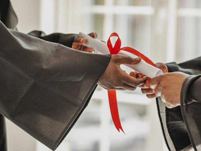 Hands passes a diploma to graduate