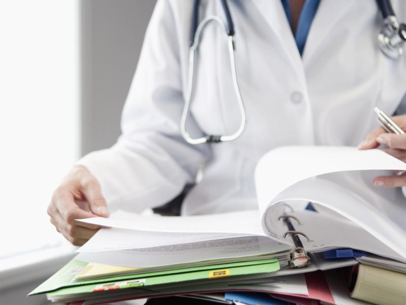 Physician reads through a binder