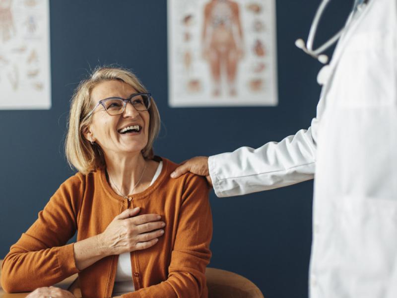 Physician with hand on smiling patient's shoulder