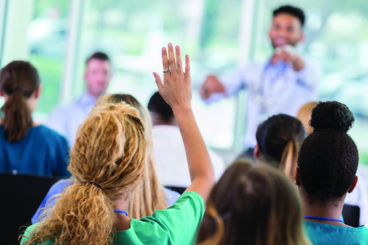 Woman raising hand to ask question