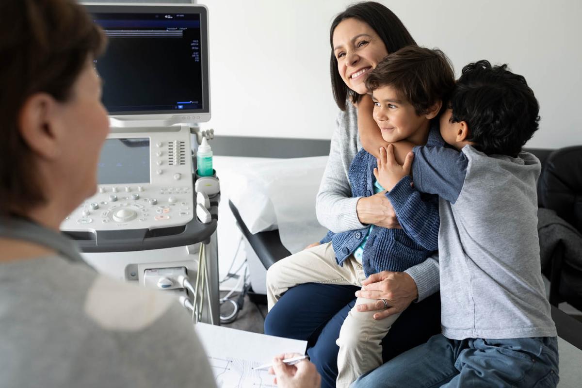 Mom hugging her kids, talking to a physician