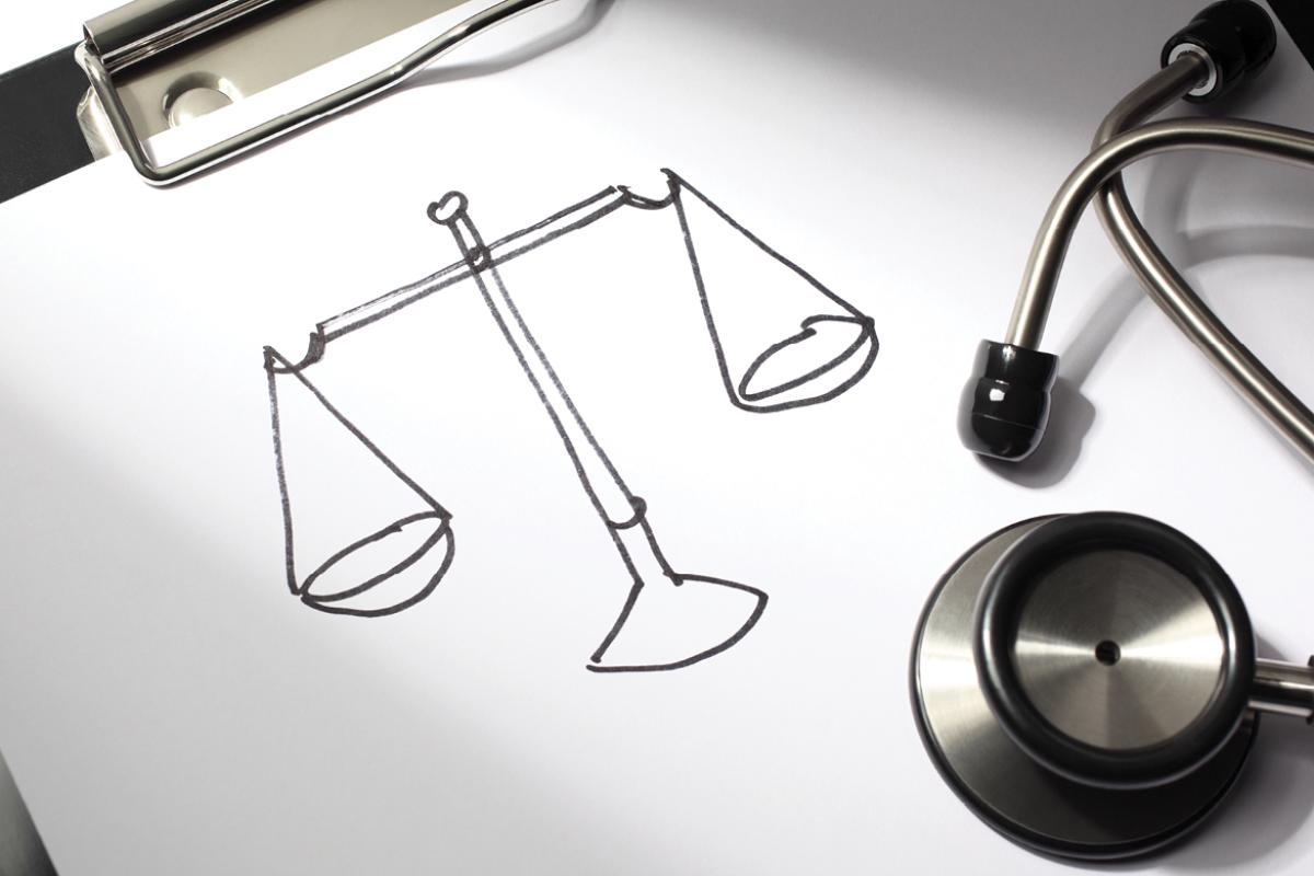 Clipboard with scales drawn on white paper, and stethoscope laying on the side