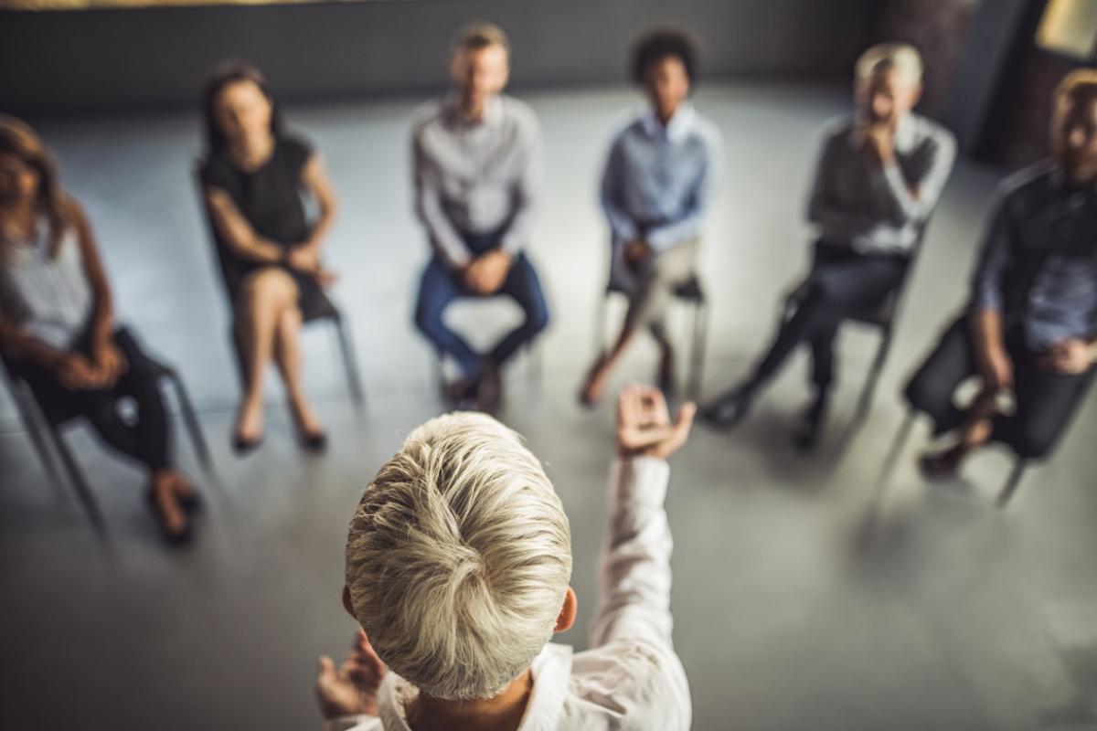 Leader talking to group sitting in a circle