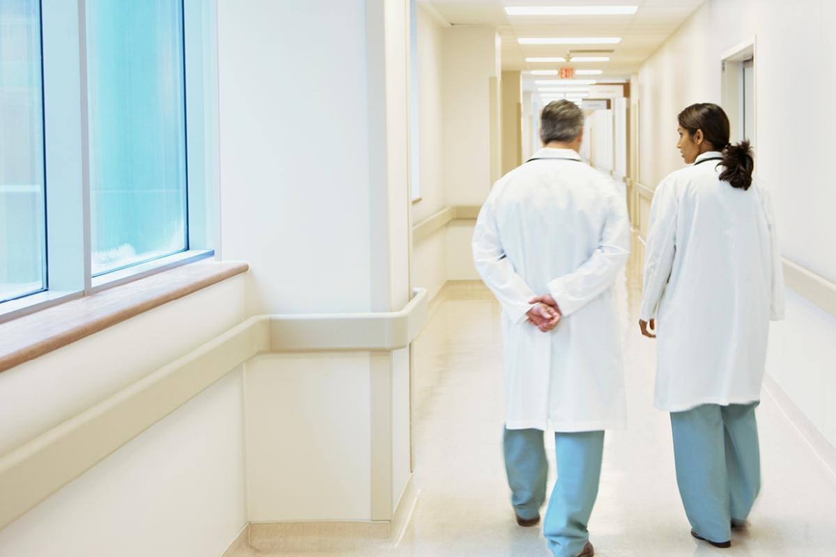 Two physicians speaking with one another