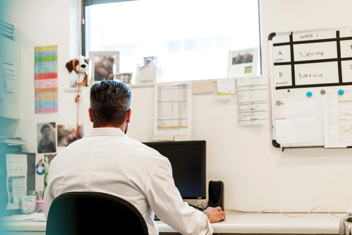 Back of man working at a desktop computer