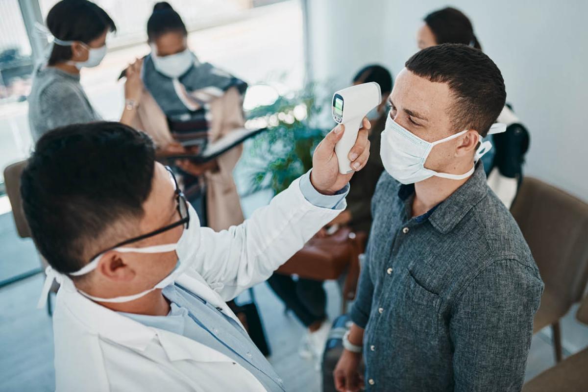 Health care worker taking patient's temperature