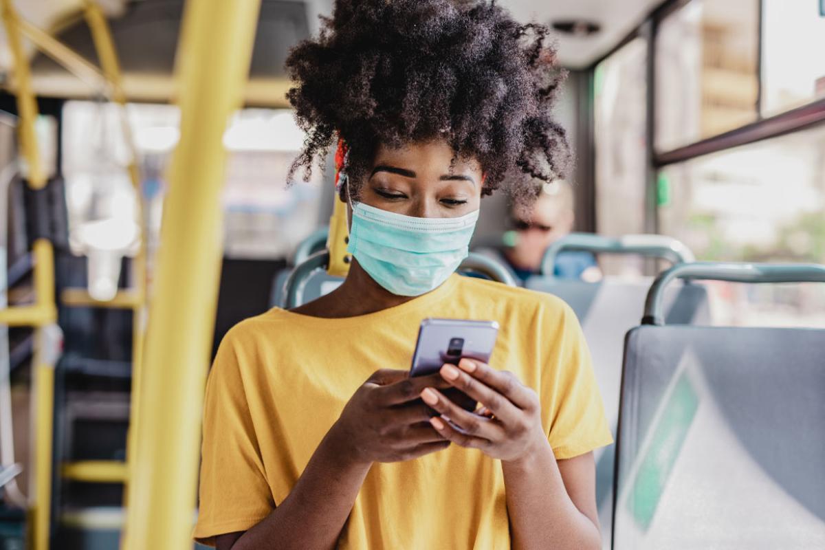 African-american woman wearing PPE on a bus