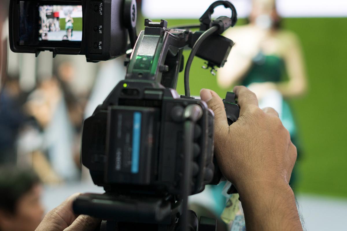 View behind a camera filming a person