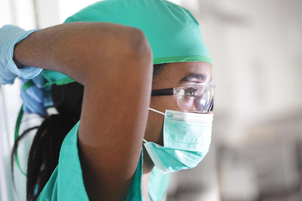 A physician masking up.