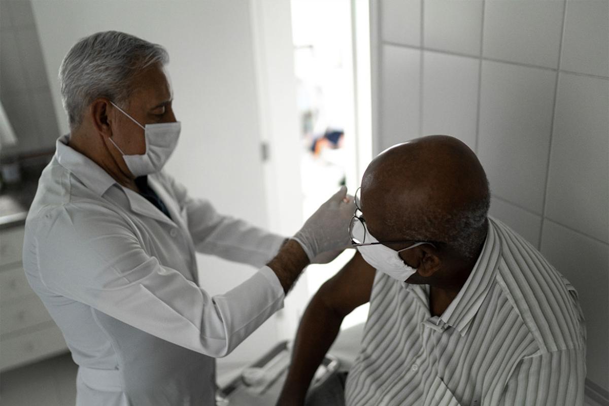 Physician administering vaccine to patient