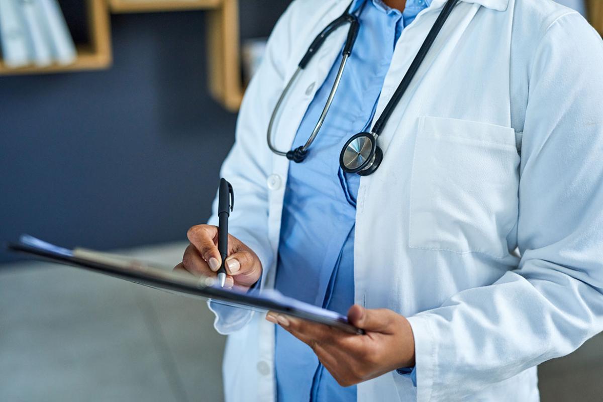 Physician writing on a clipboard