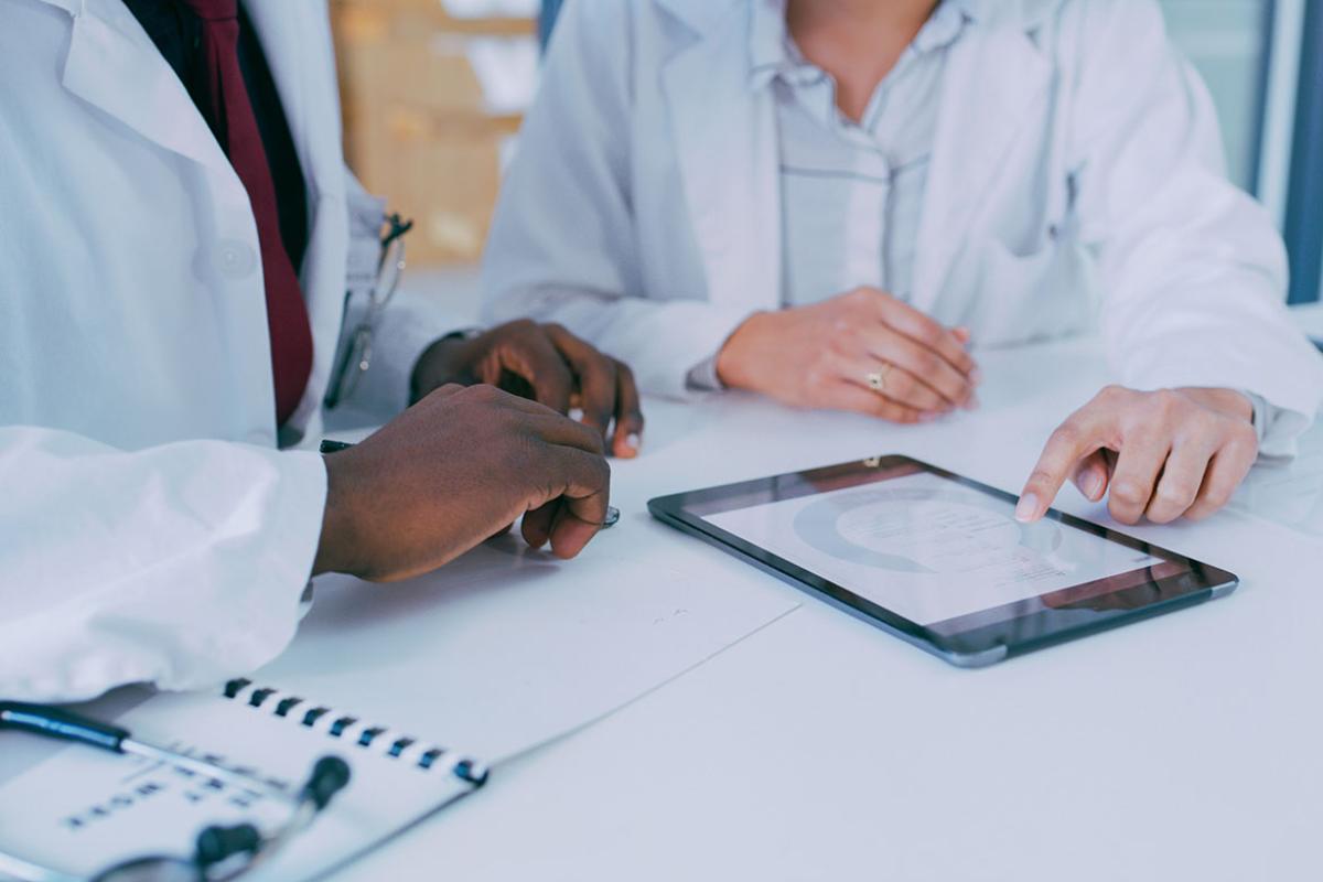 Two health care professionals looking at at tablet device