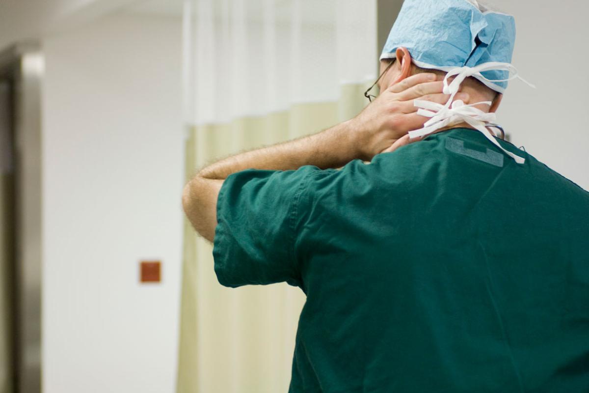 Health care professional rubbing back of neck