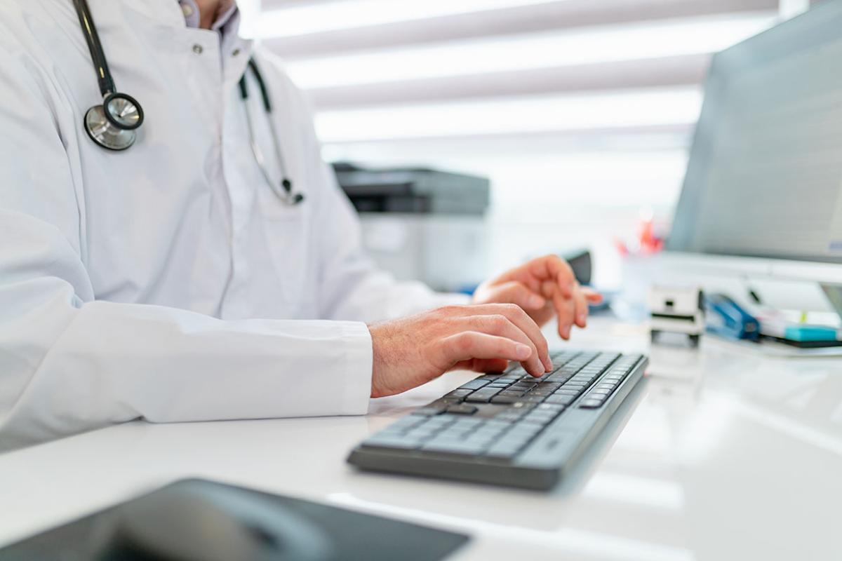 Health care worker typing on a keyboard