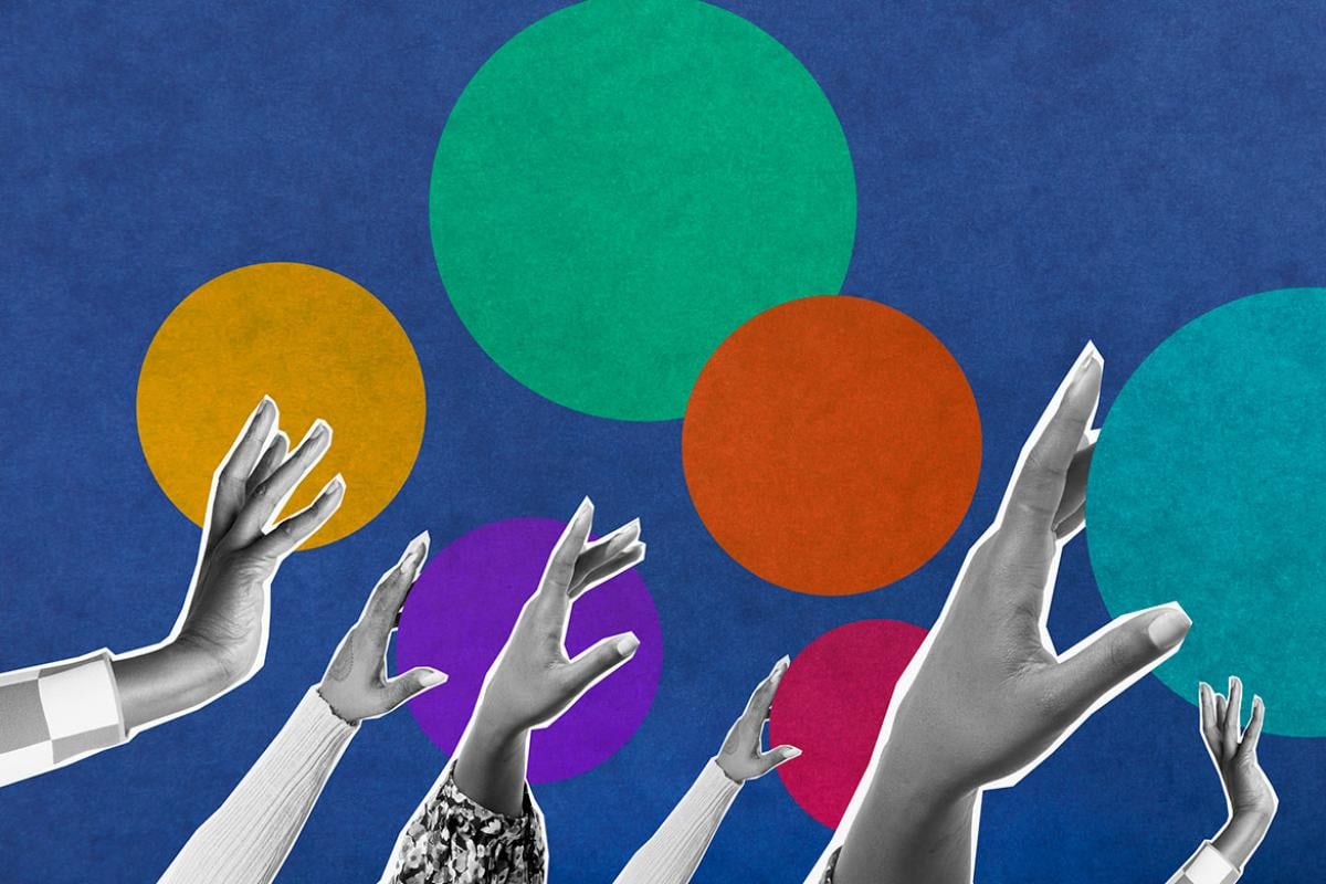 Multiple hands reaching up toward multi-colored circles
