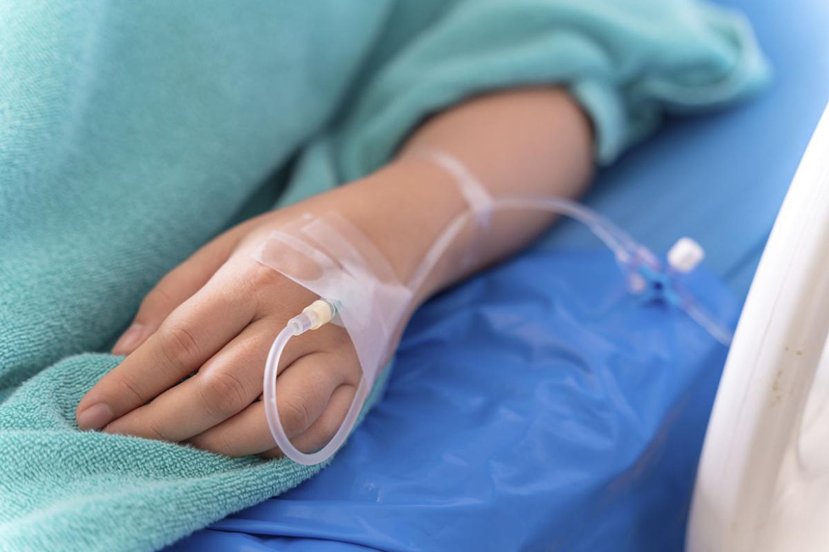 Hand of a patient on IV drip receiving a saline solution