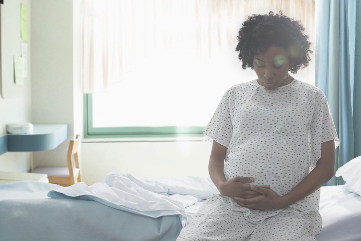 Pregnant person sitting on hospital bed