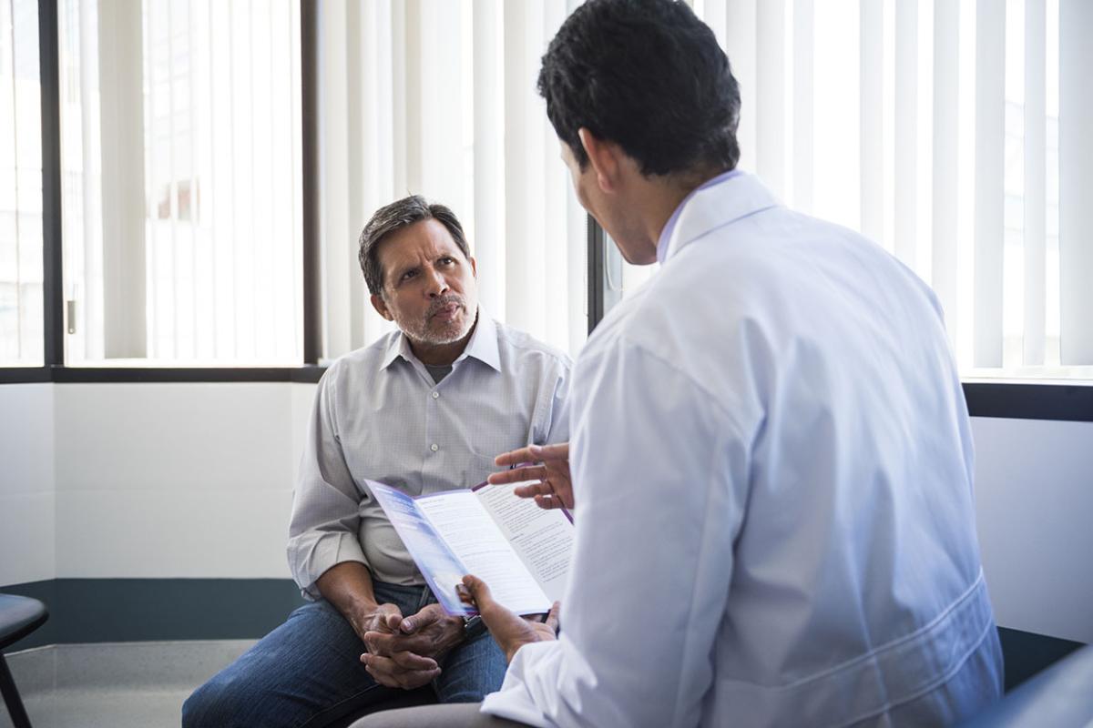Doctor holding brochure and speaking to patient