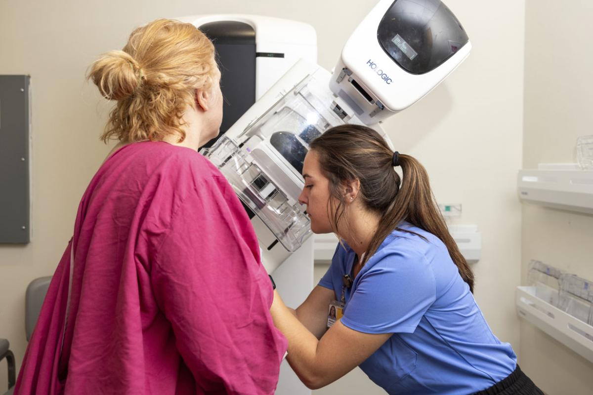 Health care worker assist a patient at a mammogram exam