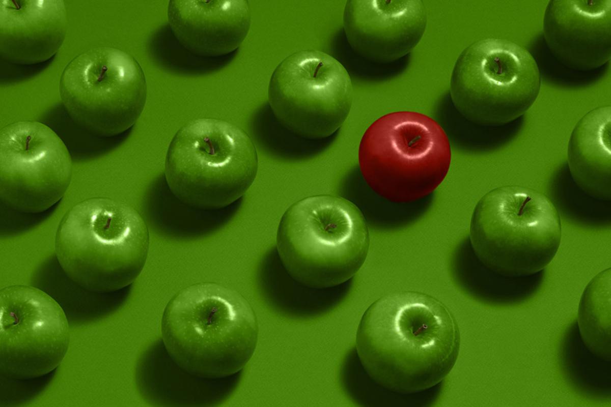 A group of green apples with one red apple