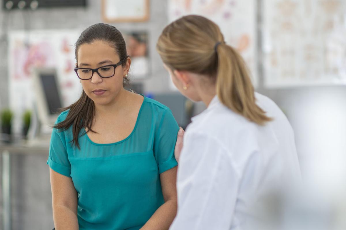 Doctor places comforting hand on patient's arm