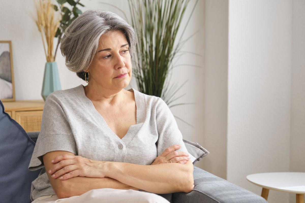 Solemn woman sits on a couch