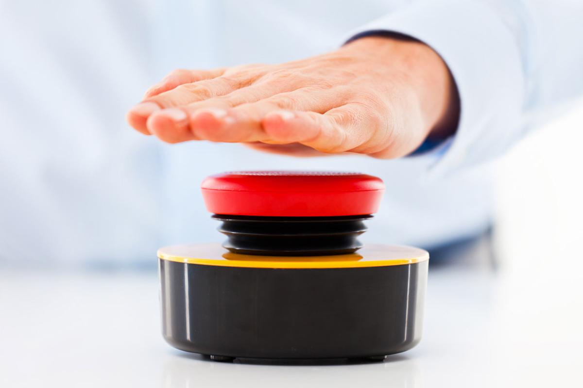 Hand hovers over a red button