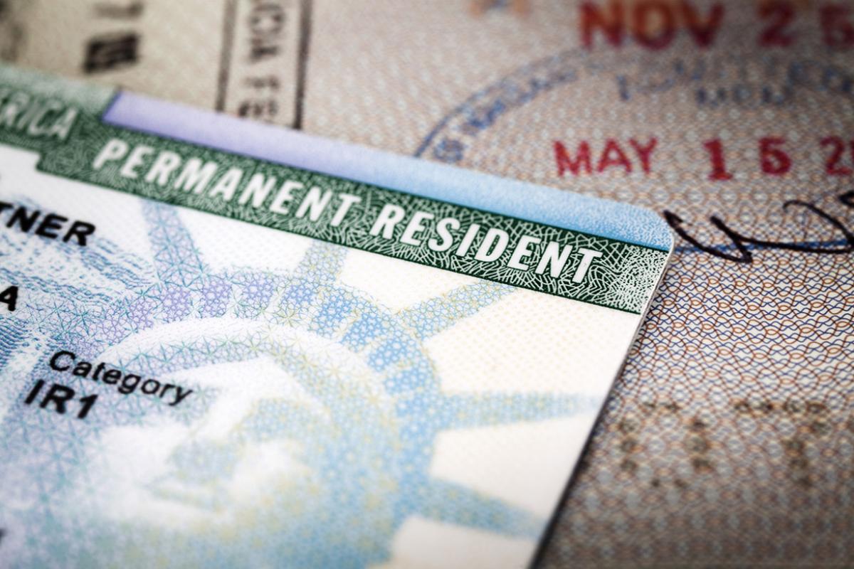 A green card lying on an open passport