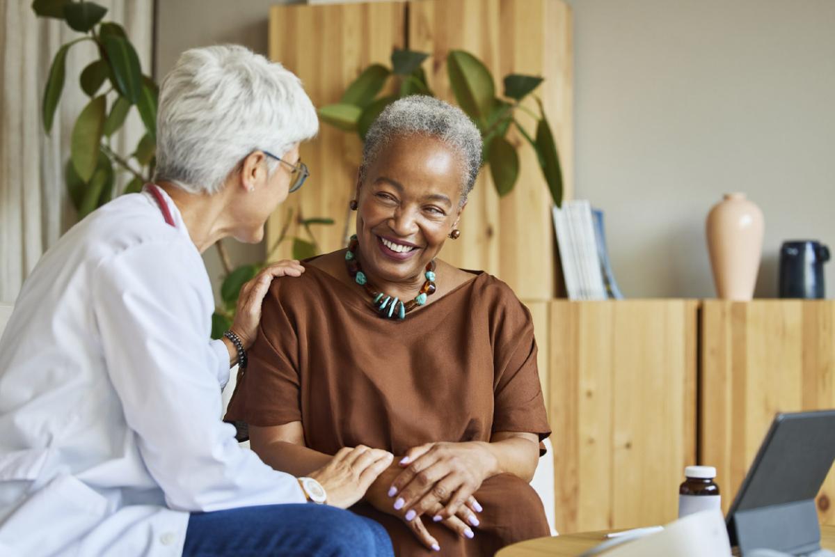 Doctor places reassuring hands on a smiling patient