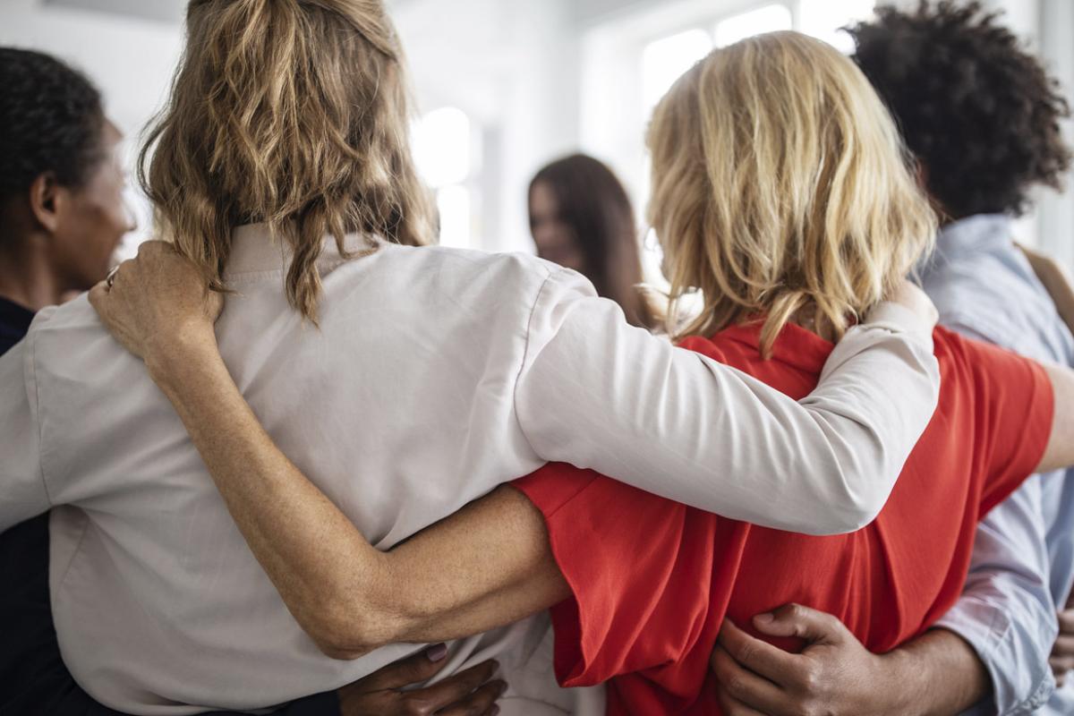 Group in a huddle with arms around one another