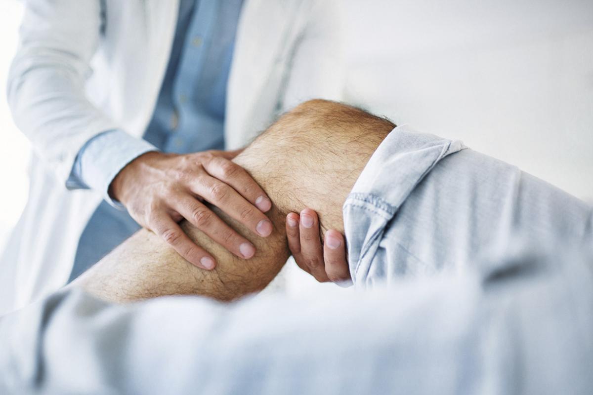 Doctor examining a knee of a patient