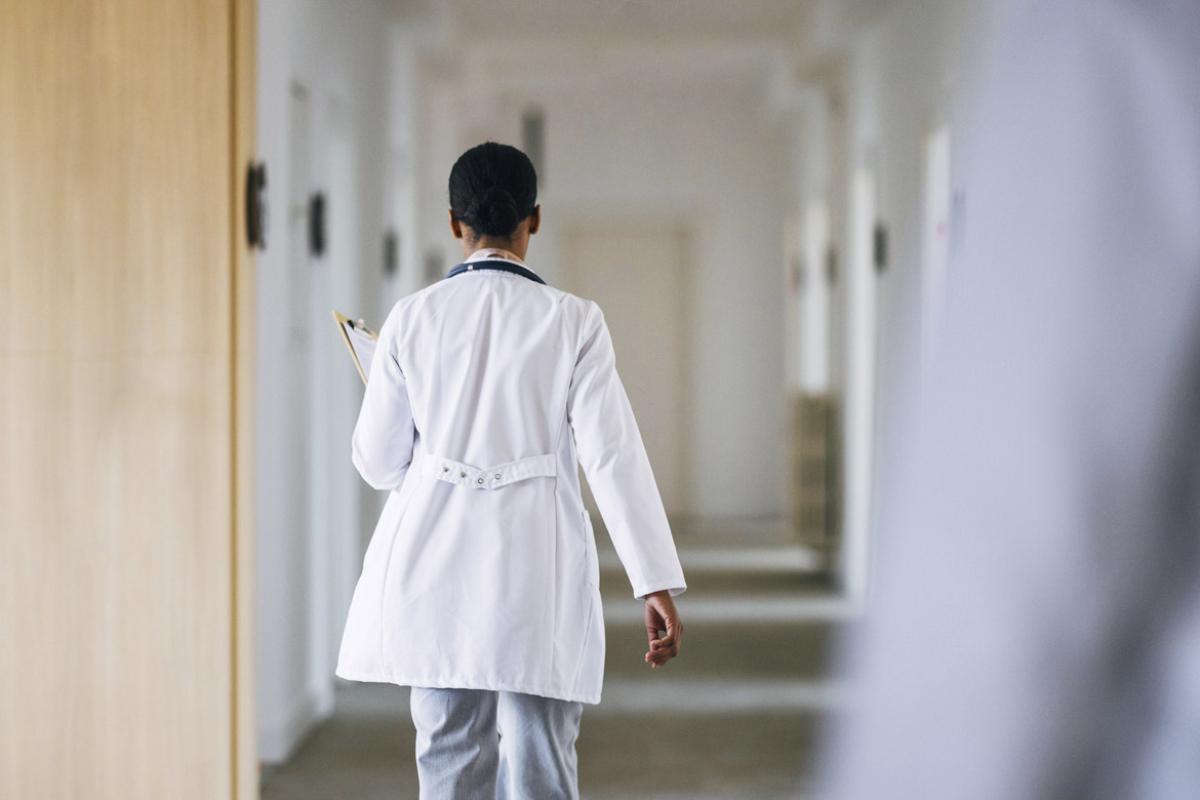 Physician walks down hallway