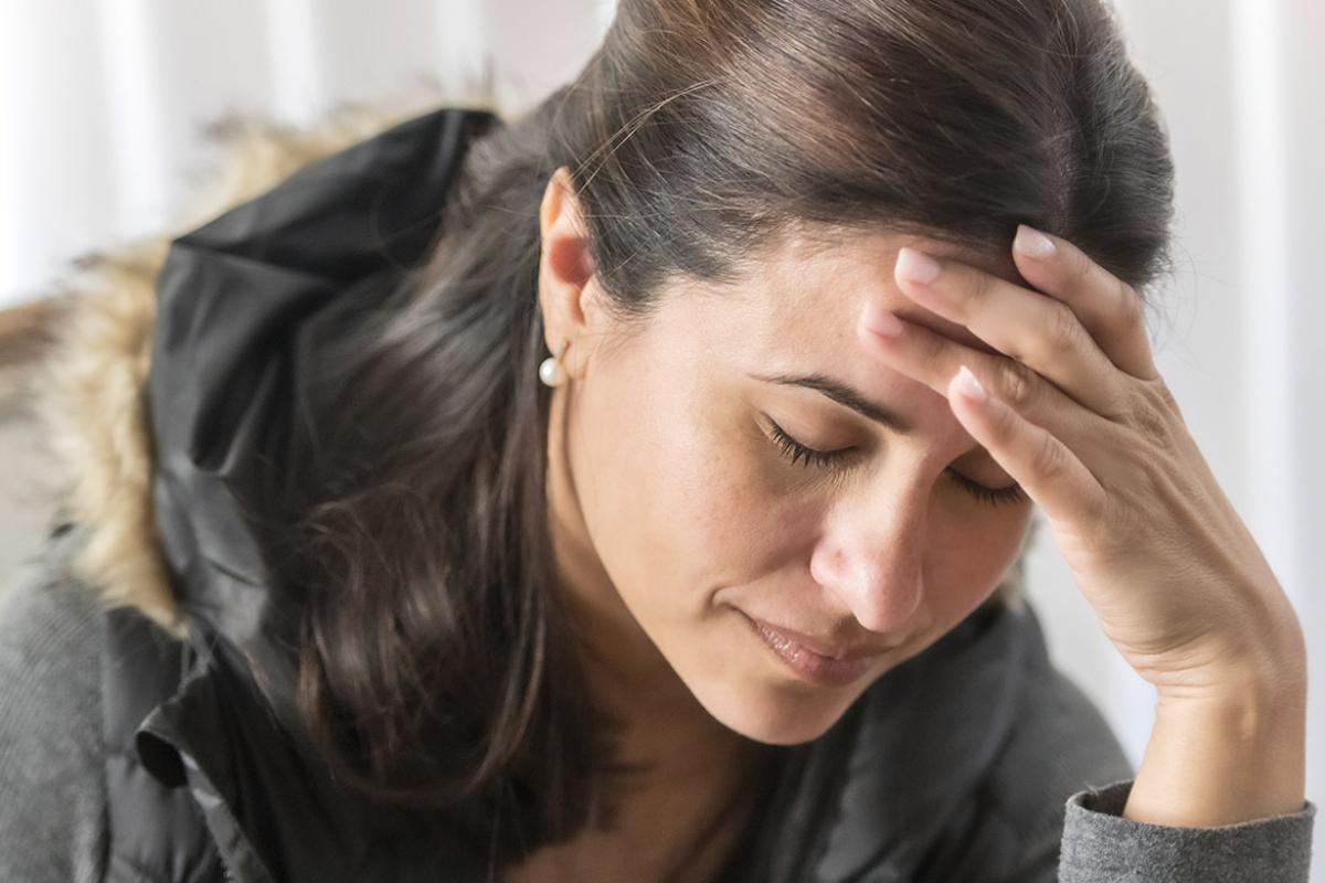 Woman with closed eyes, head in hand