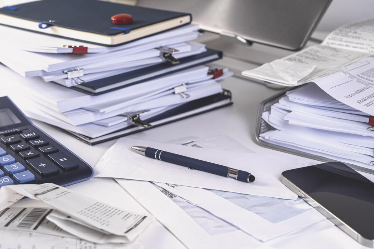 Stacks of documents, calculator, pen and smartphone