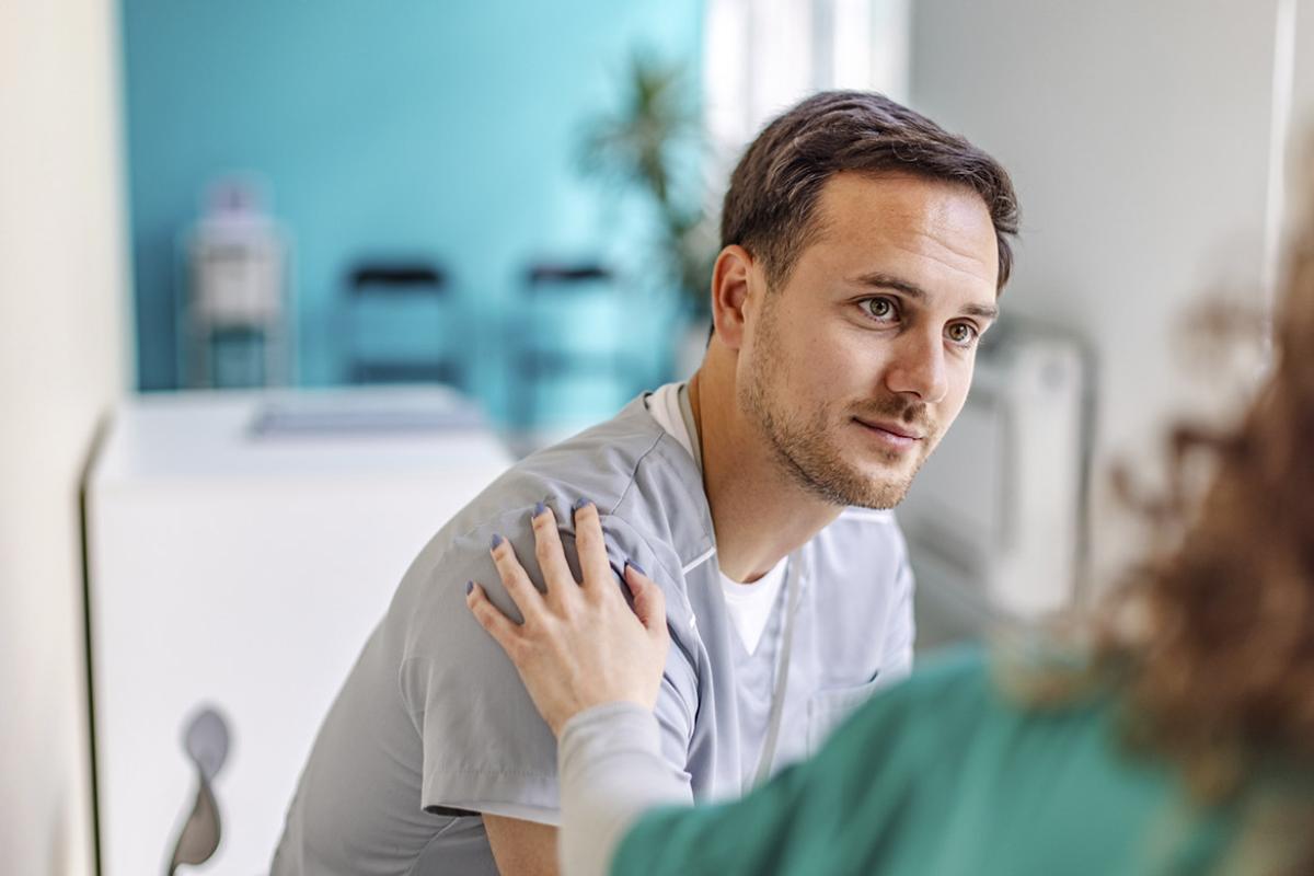 Healthcare worker with hand on patient's shoulder