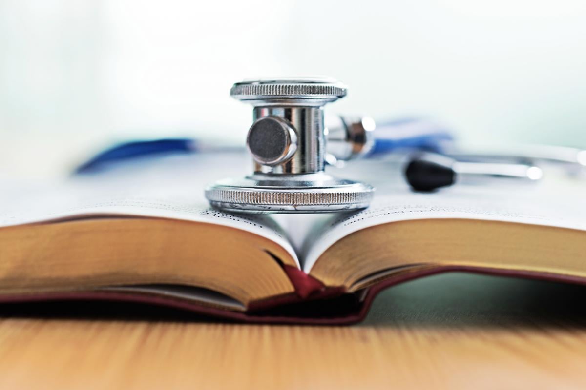 Closeup of stethoscope and book.