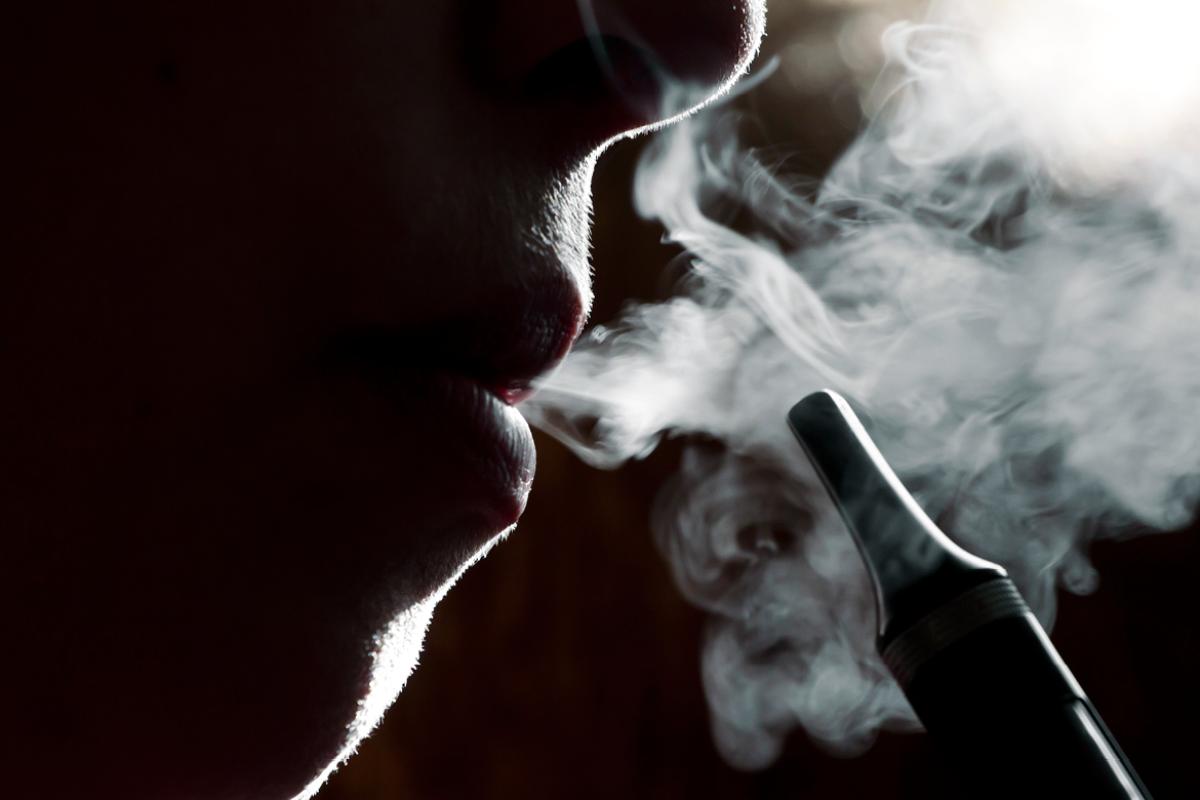 Mouth exhaling vapor from an e-cigerette.