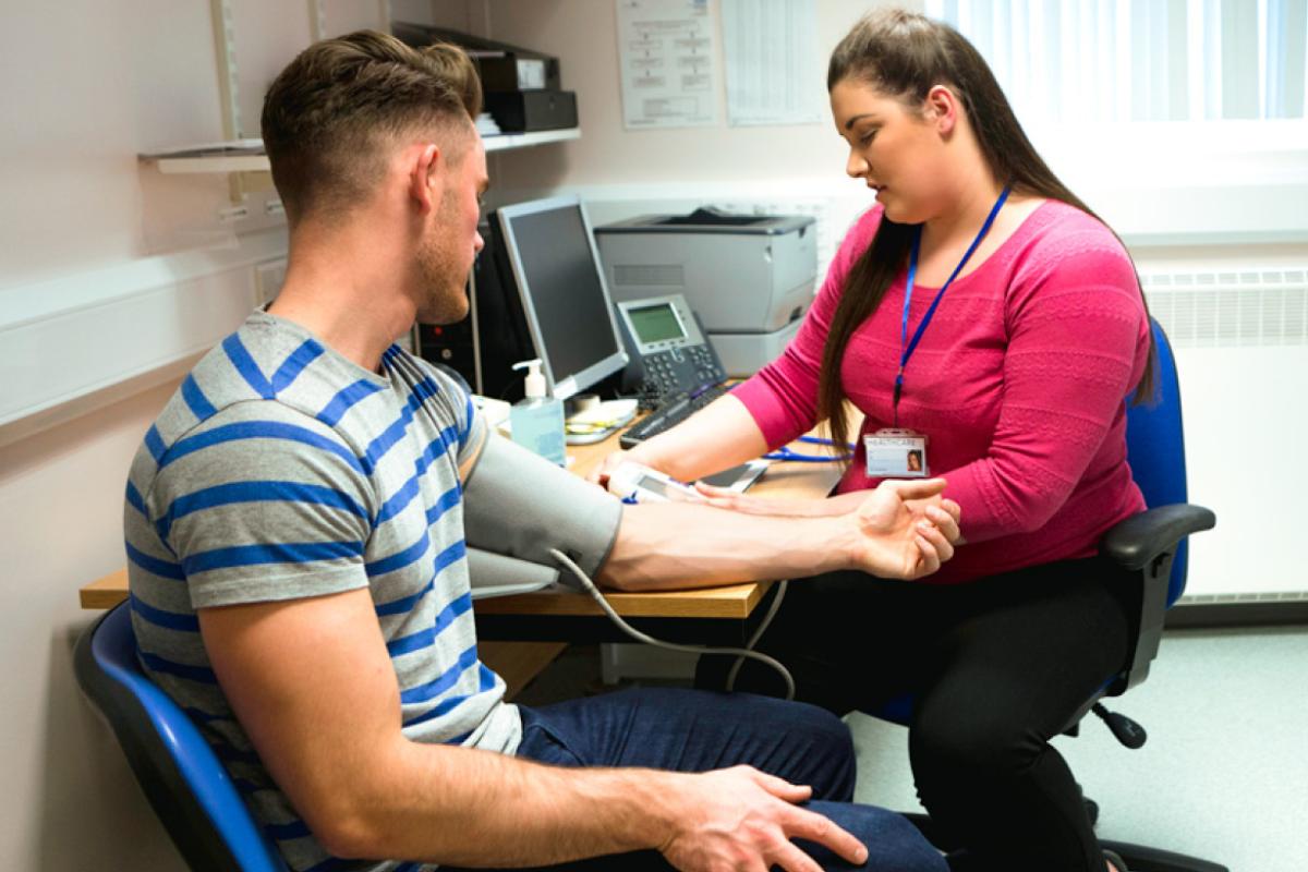 Medical student measuring the blood pressure of patient. 