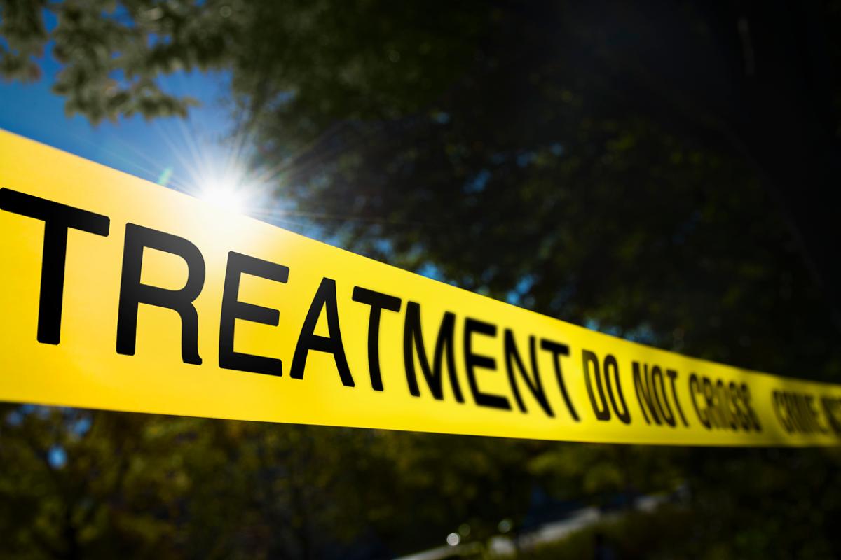Yellow scene tap barring entrance to treatment. 