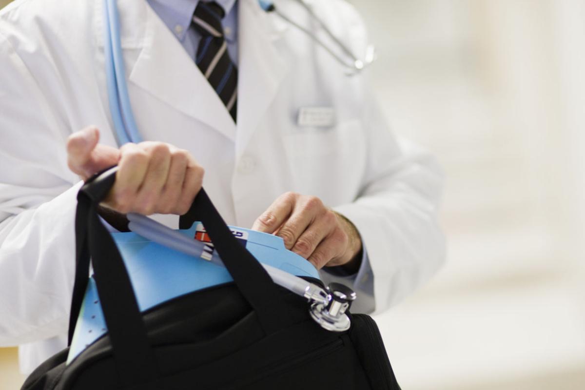 Physician with bag in hand.