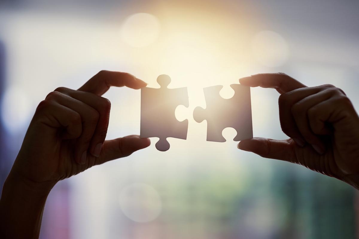 Two pieces of a puzzle being put together. 