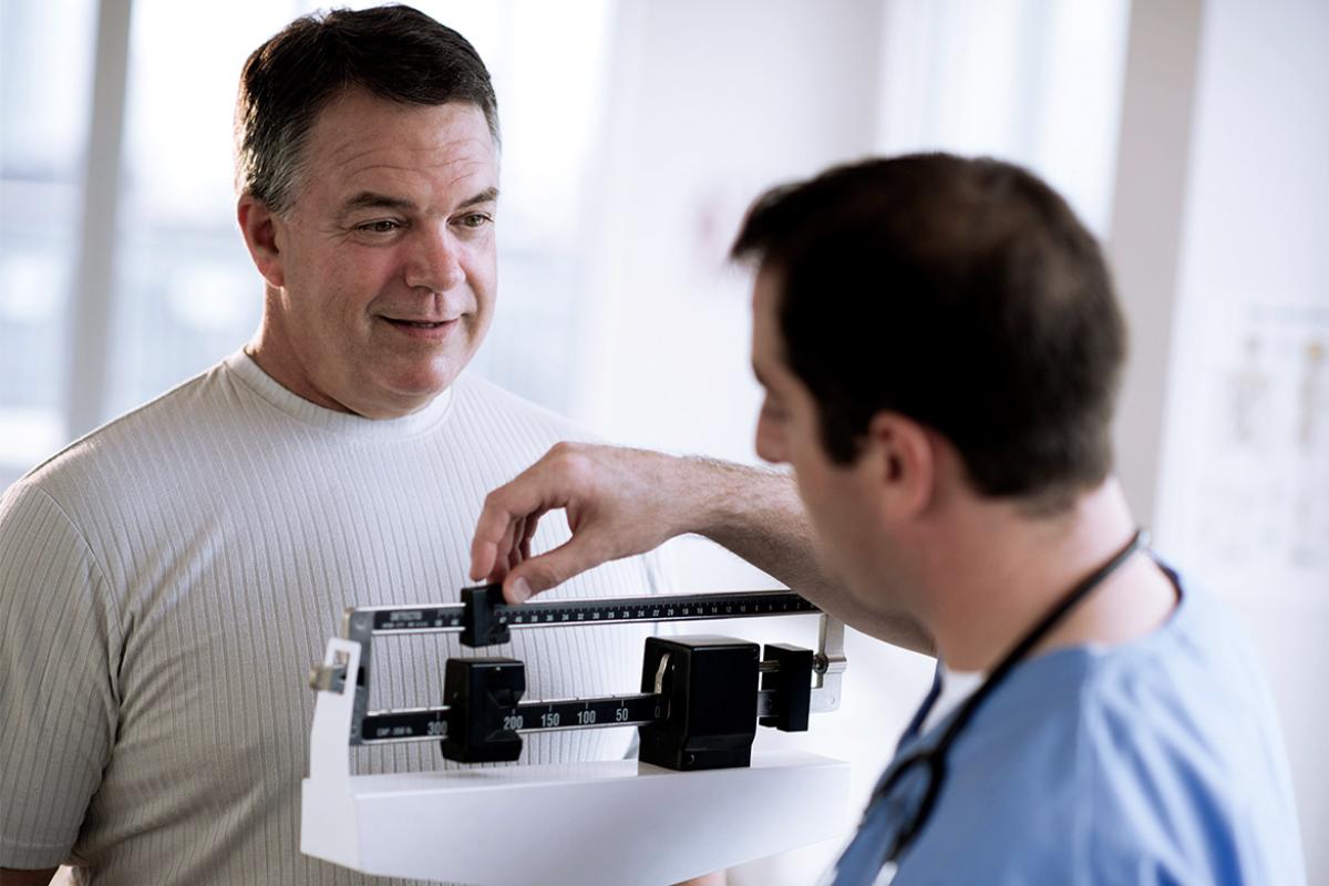Doctor takes patients weight.