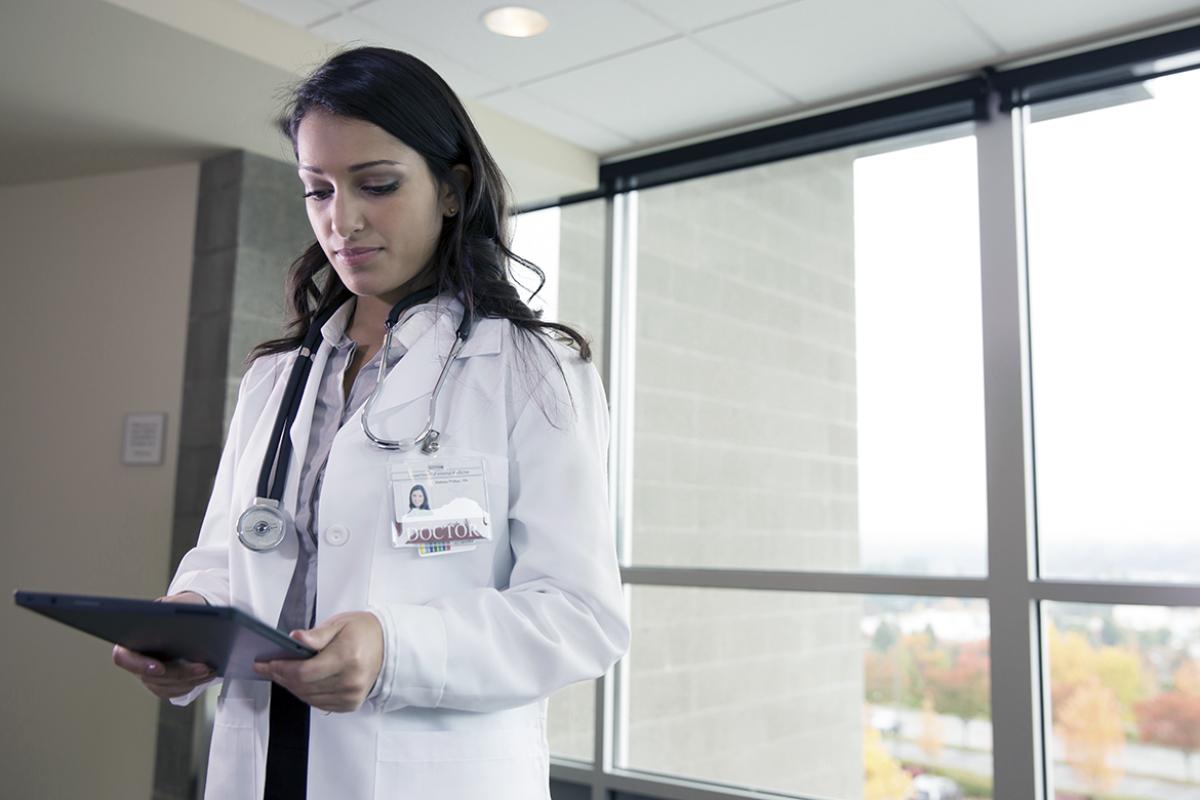 Female physician looking at digital tablet.